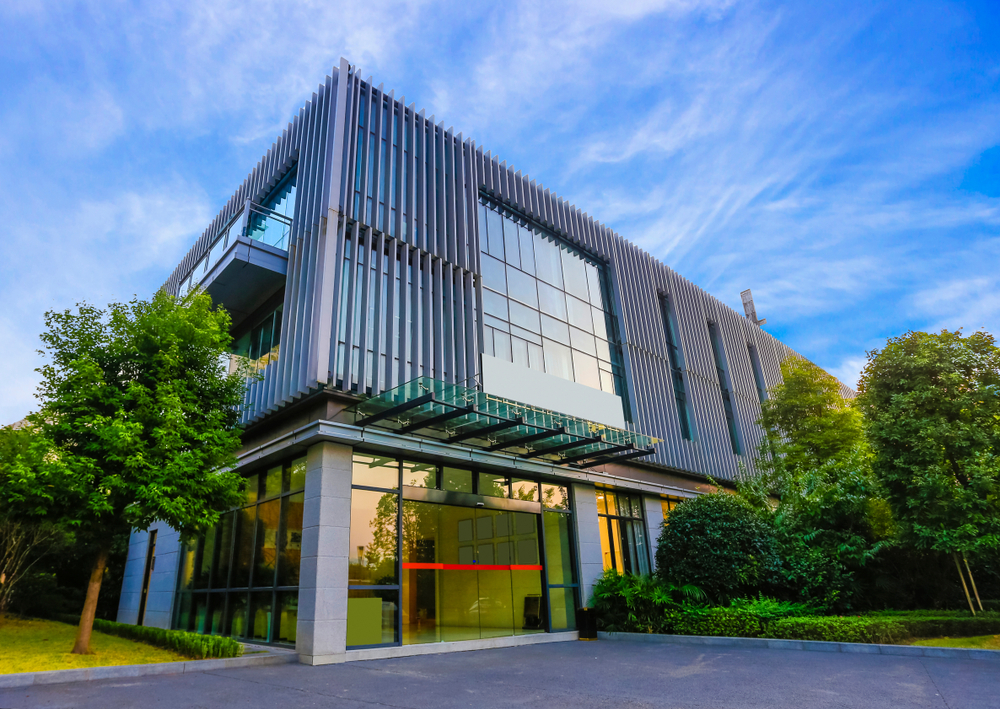 The,Office,Building,Is,At,Dusk. Modern multi-story commercial building exterior with glass facade.