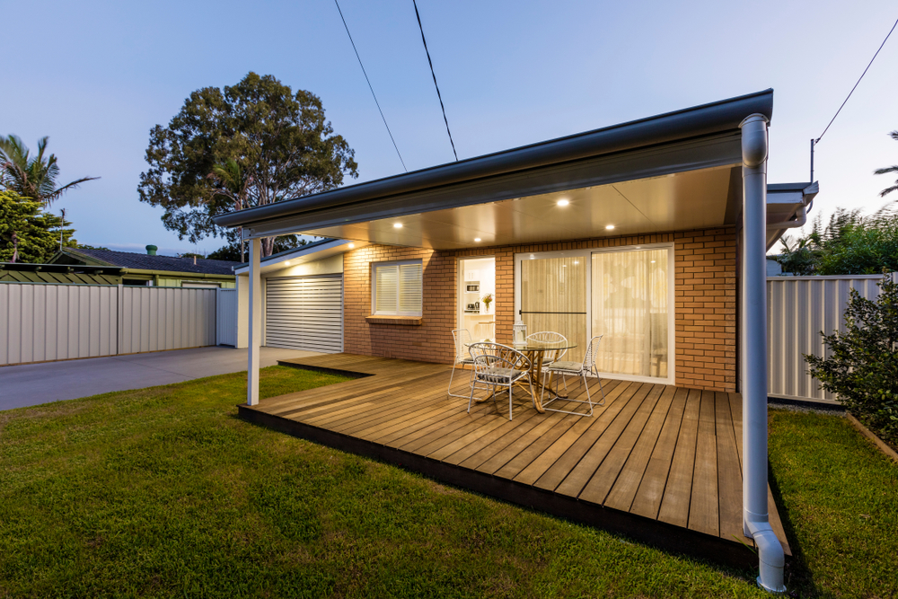 Modern,Australian,Home,Front,At,Dusk Modern home patio and backyard wooden deck with outdoor lighting.