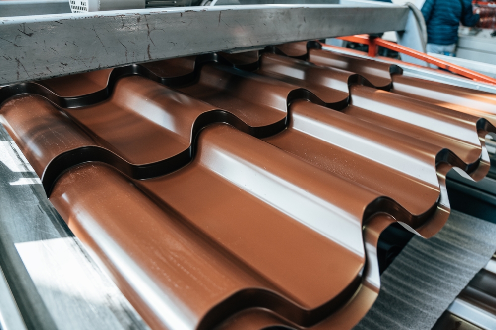 Brown,Metal,Roof,Tiles,Made,From,Galvanized,And,Painted,Steel Metal roof tile manufacturing machine forming copper-colored roofing panels.