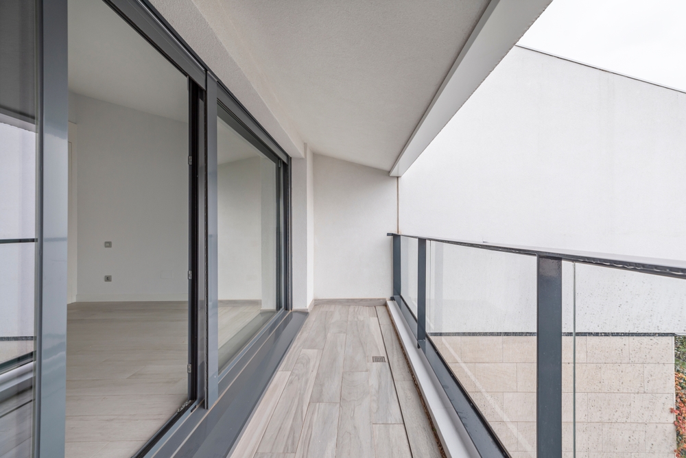 Handles,Integrated,Into,Gray,Aluminum,Profiles,For,Sliding,Terrace,Windows Modern balcony area with sliding glass doors and railings.
