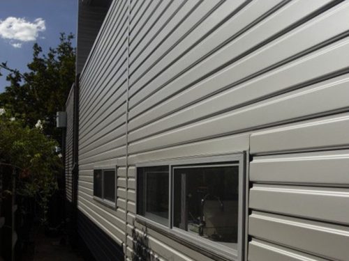 Stramit-C-280-Walling-Application-Image-500×375 Exterior building facade featuring light gray metal wall cladding panels.