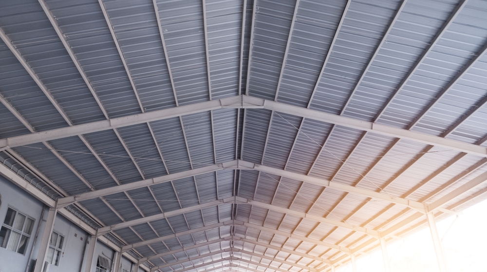 Steel,Roof,Frame,Building,Construction,In,The,Industry,metal,Roof,In Interior view of a large warehouse ceiling with steel truss framing and insulation.